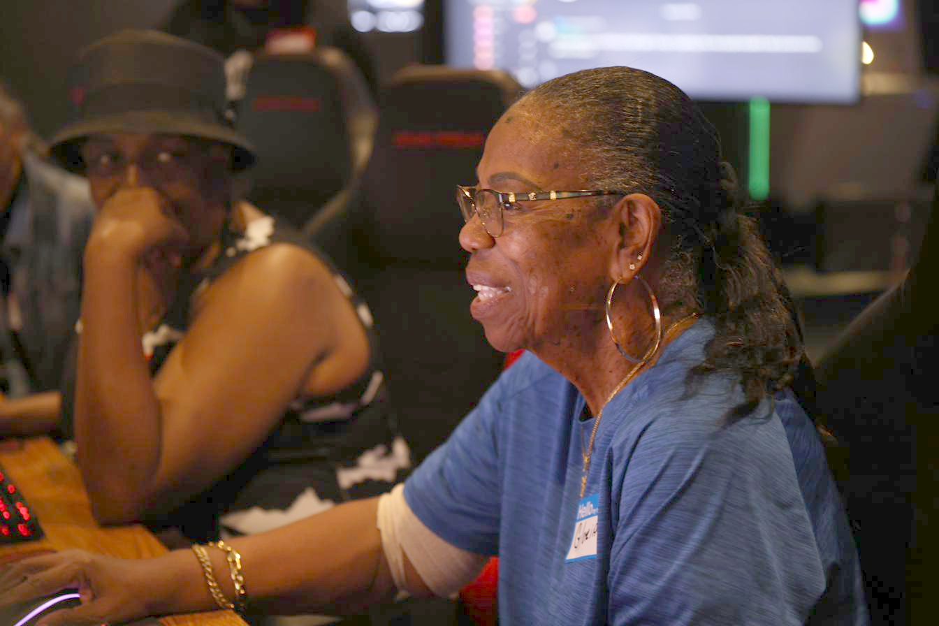A senior player smiling mid-match at a Senior Esports USA training event